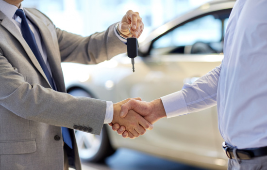 Dealer handing keys to owner